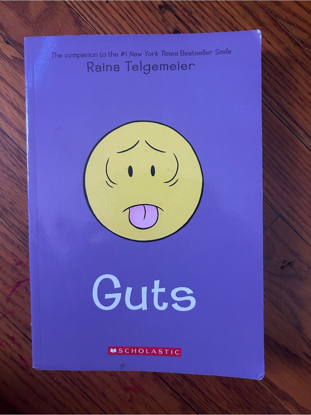 Scholastic Purple 'Guts' Graphic Novel with Yellow Emoticon